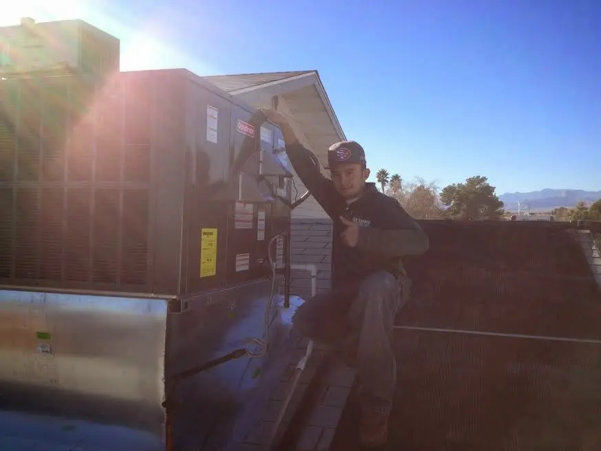 HVAC technician performing AC Tune-Up on a rooftop unit in Christiansburg